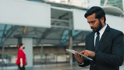 Concentrated business man going from work with modern tablet Stock Footage 303912626