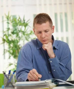 Concentrated businessman  analyzing data in his office Stock Photos