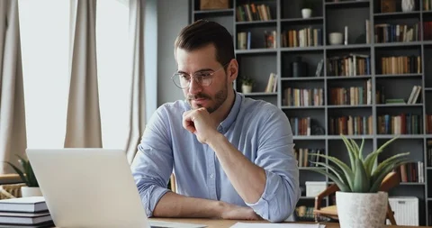 Concentrated businessman thinking of problem solution working on laptop Stock Footage 125983993