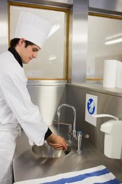 Concentrated chef washing hands Stock Photos