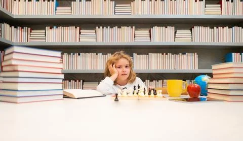 Concentrated child boy developing chess strategy, playing board game. Stock Photos