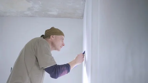Concentrated craftsman fixes white wallpaper edges on wall Stock Footage 108582471