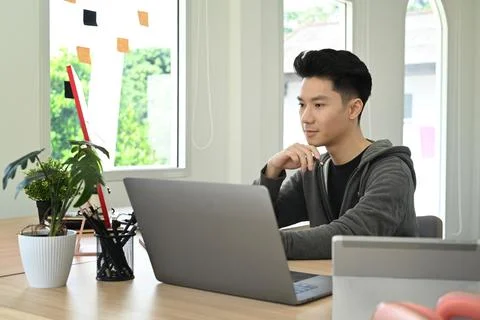 Concentrated creative man working on design project at bright modern office Stock-Fotos