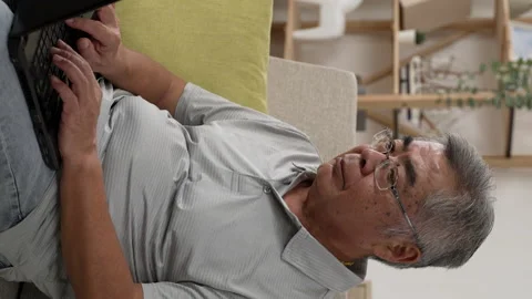 Concentrated elderly asian man using laptop Stock Footage 229620080