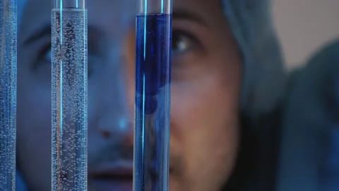 Concentrated eyes observe the diffusion of dissimilar liquids in test tubes in t Stock Footage 233031065