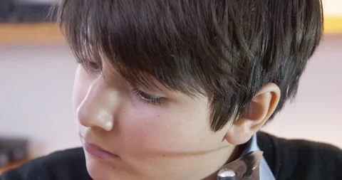 The concentrated face of a boy repairing a complex technical mechanism of a Stock Footage 169985135