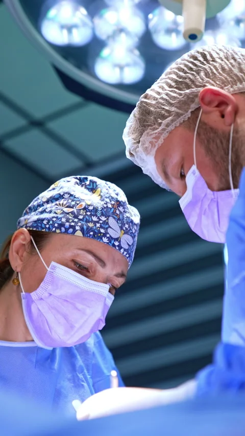 Concentrated faces of two doctors leaned over the patient. Stock Footage 281375914