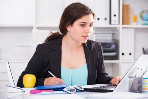 Concentrated female trainee is having productive day at work Stock Photos