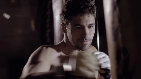 Concentrated fit man working out beating the boxing bag. Stock-Footage 76917596