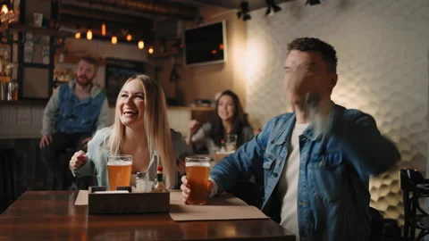 Concentrated five young friends watching football match while drinking beer and Stock Footage 186242298