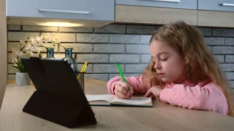 Concentrated girl is writing the topic while listening to the teacher on the 스톡 동영상 150139265