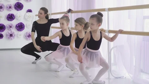 Concentrated girls are learning basic ballet positions in dancing school with Stock Footage 108593187