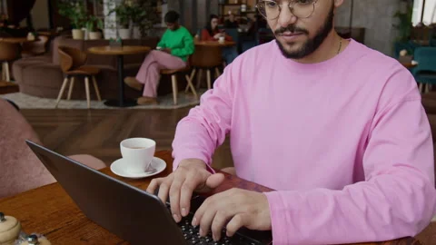 Concentrated Guy Working on Laptop in Restaurant, with Cup of Coffee on Table Stock Footage 333251693