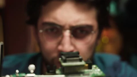 Concentrated hacker looking at microchip close-up. Young Spanish man developing Stock-Footage 164769591
