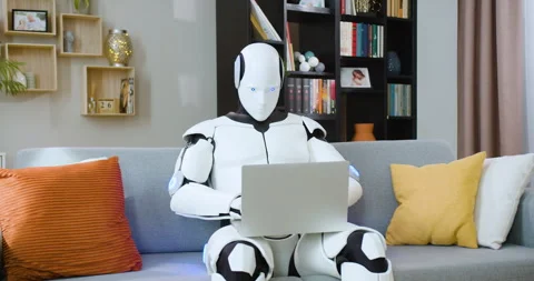 Concentrated humanoid robot working on wireless laptop while sitting on Stock Footage 244136687