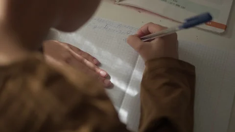 Concentrated kid school boy solving math problem studying lesson doing homework Stock Footage 253784560