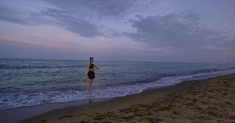 Concentrated lady practicing yoga in the middle of beach side take the Video stock 115206906