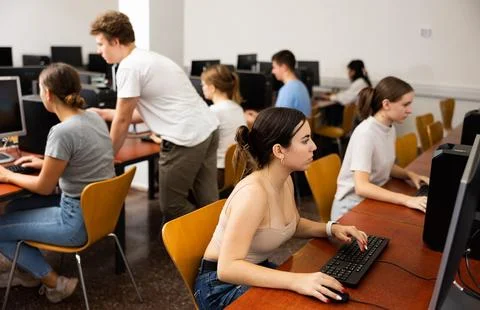 Concentrated Latin female student using PC and studying computer science in the Stock Photos