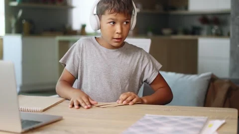 Concentrated little multiethnic school boy makes an airplane Stock Footage 248690193