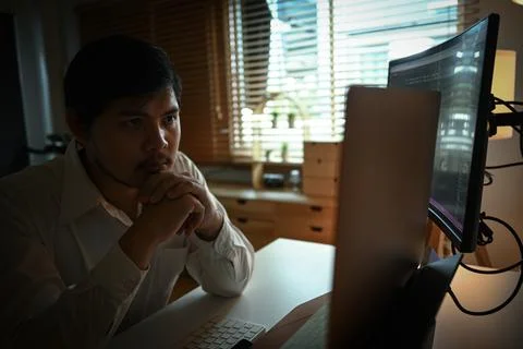 Concentrated male software developer programming code on the computer for cyber Stock Photos