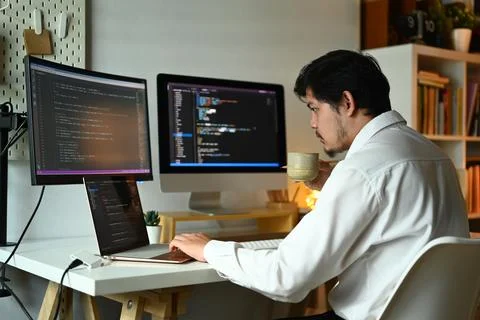 Concentrated male web developer working with coded data on computer screen Stock Photos