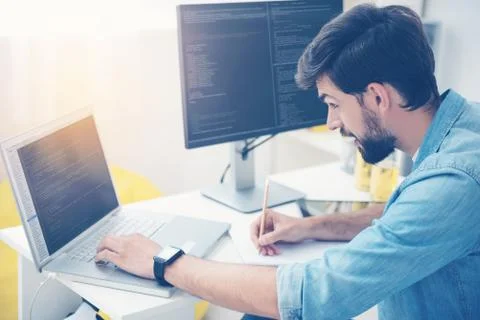 Concentrated man coding on a laptop 스톡 사진