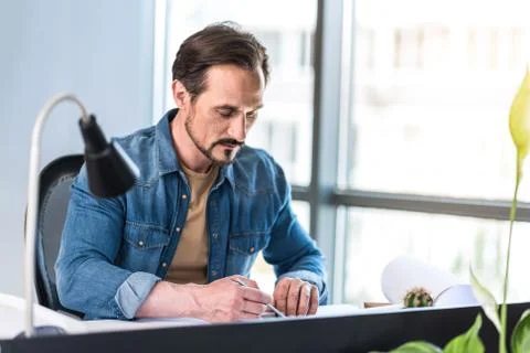 Concentrated man creating draft in office Foto stock
