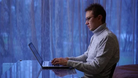 Concentrated man freelancer in eyeglasses working remotely at home Stock Footage 169319207