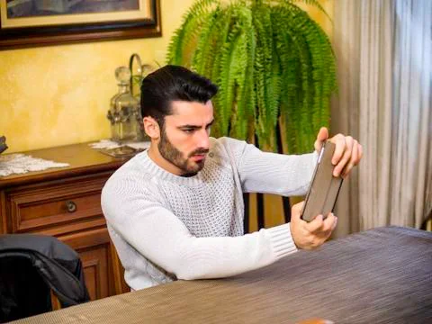 Concentrated man playing with tablet Stock Photos