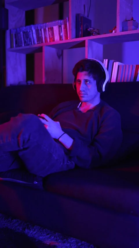 A concentrated man playing video games with headphones looking at the tv screen Stock Footage 199128756