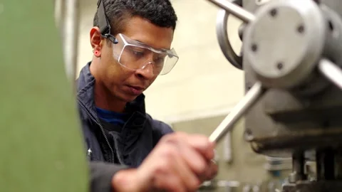 Concentrated man with protective goggles using a milling machine Stock-Footage 257491718