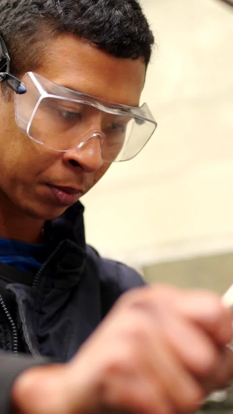 Concentrated man with protective goggles using a milling machine Stock Footage 259668418