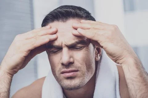 Concentrated man touching forehead with his hands Stock Photos
