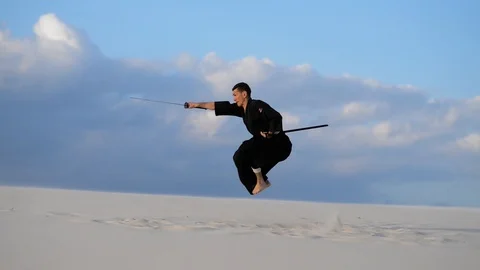 Concentrated man training martial arts in desert Video stock 101485370
