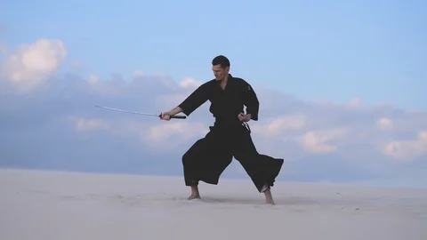 Concentrated man training martial arts in desert Video stock 101485380