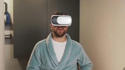 Concentrated man in virtual reality glasses brushing his teeth and Stock Footage 229704163