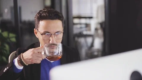Concentrated man work with computer drink tea in cup Stock Footage 80910429