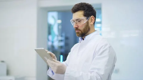 Concentrated mature man scientist in white coat with protective glasses  Stock Footage 233292940