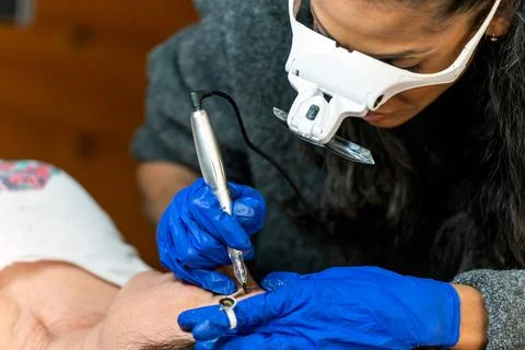 Concentrated microblading master applying permanent eyebrows makeup Stock Photos