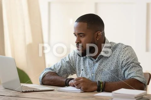 Concentrated millennial african american guy focused on online university Stock Photos