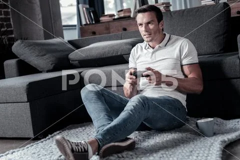 Concentrated millennial guy playing video games Stock Photos