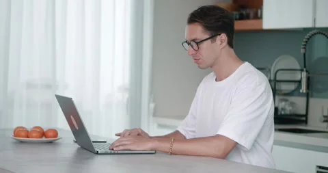 Concentrated millennial man in glasses typing on laptop computer, surfing the Stock Footage 237237723
