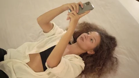 Concentrated mixed race lady types on smartphone playing Stock Footage 158526005