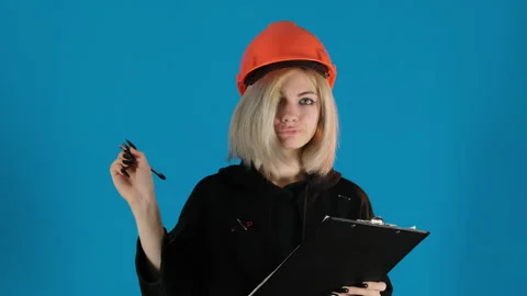 Concentrated model in helmet writes down important information Stock Footage 306502199