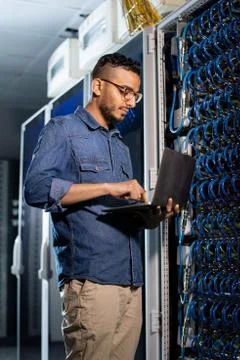 Concentrated network engineer examining database server Stock Photos