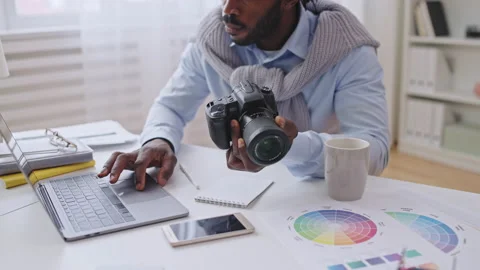 Concentrated photographer adjusting camera settings according to online tutorial Stock Footage 188138986