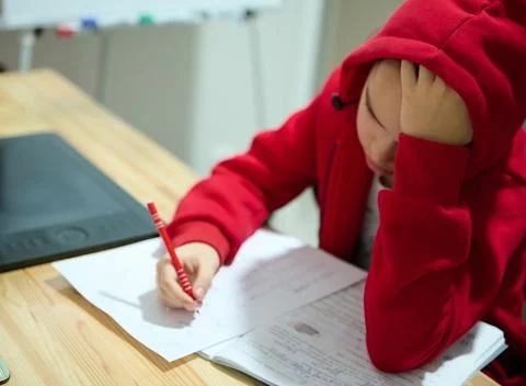 Concentrated preadolescent school boy solving math problems while doing homwe Stock Photos