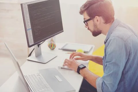 Concentrated programmer coding in an office Stock-Fotos