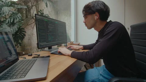 Concentrated Programmer Writing Code on Computer in Home Office Stock Footage 252756986