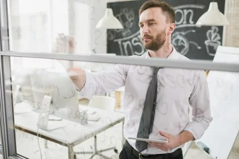 Concentrated programmer writing code on glass Stock Photos